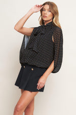 Black woven top with gold dot print, bow neck and pleated front