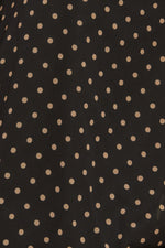 Close-up of black woven fabric with small gold dot pattern
