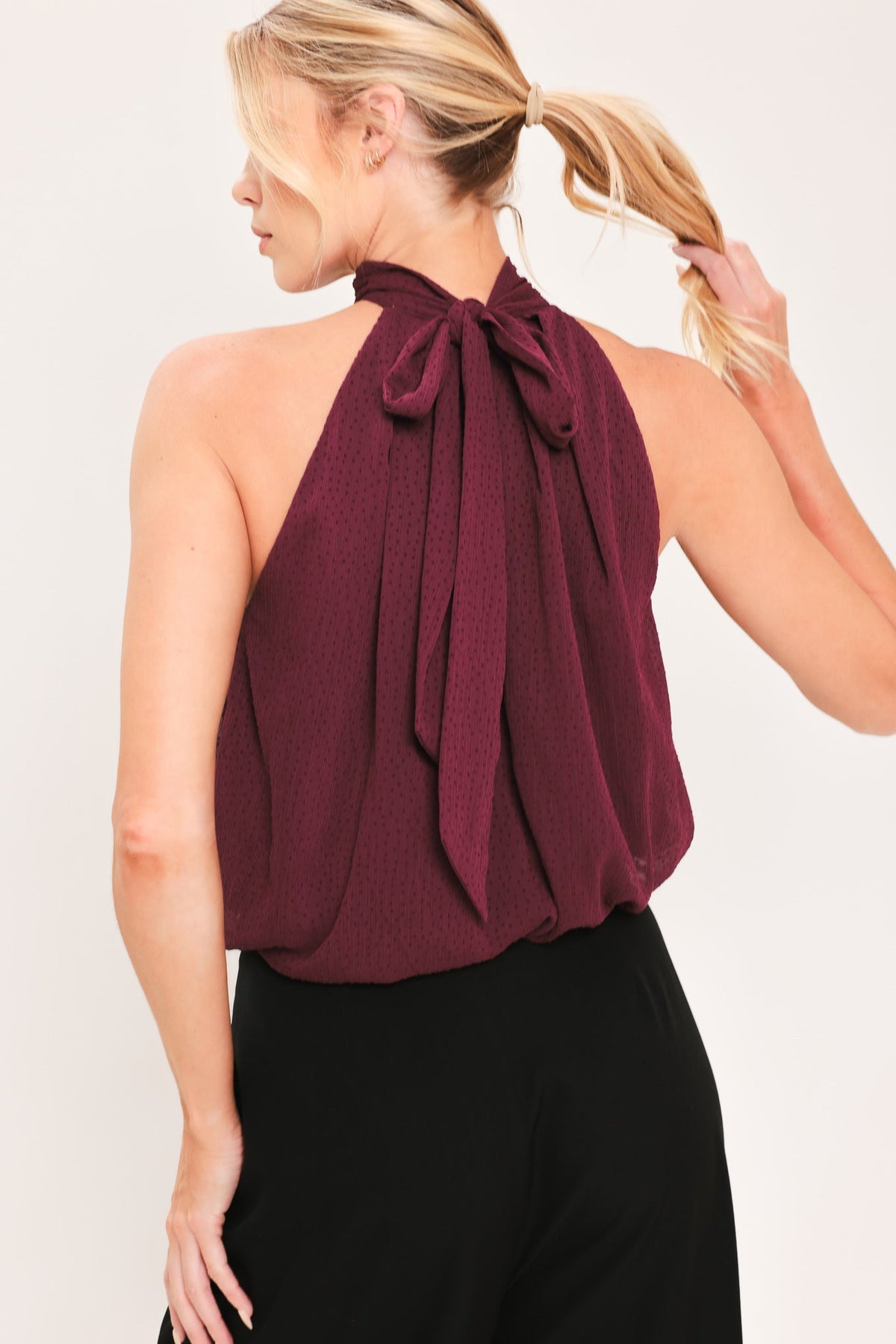 Burgundy halter woven drape top with bow at back neck and gathered pleats