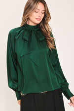 Hunter green tie-neck raglan top with bow at neckline and relaxed sleeves