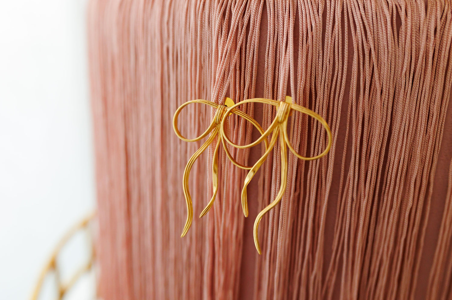 Gold-tone looped drop earring with dangling tassel strands