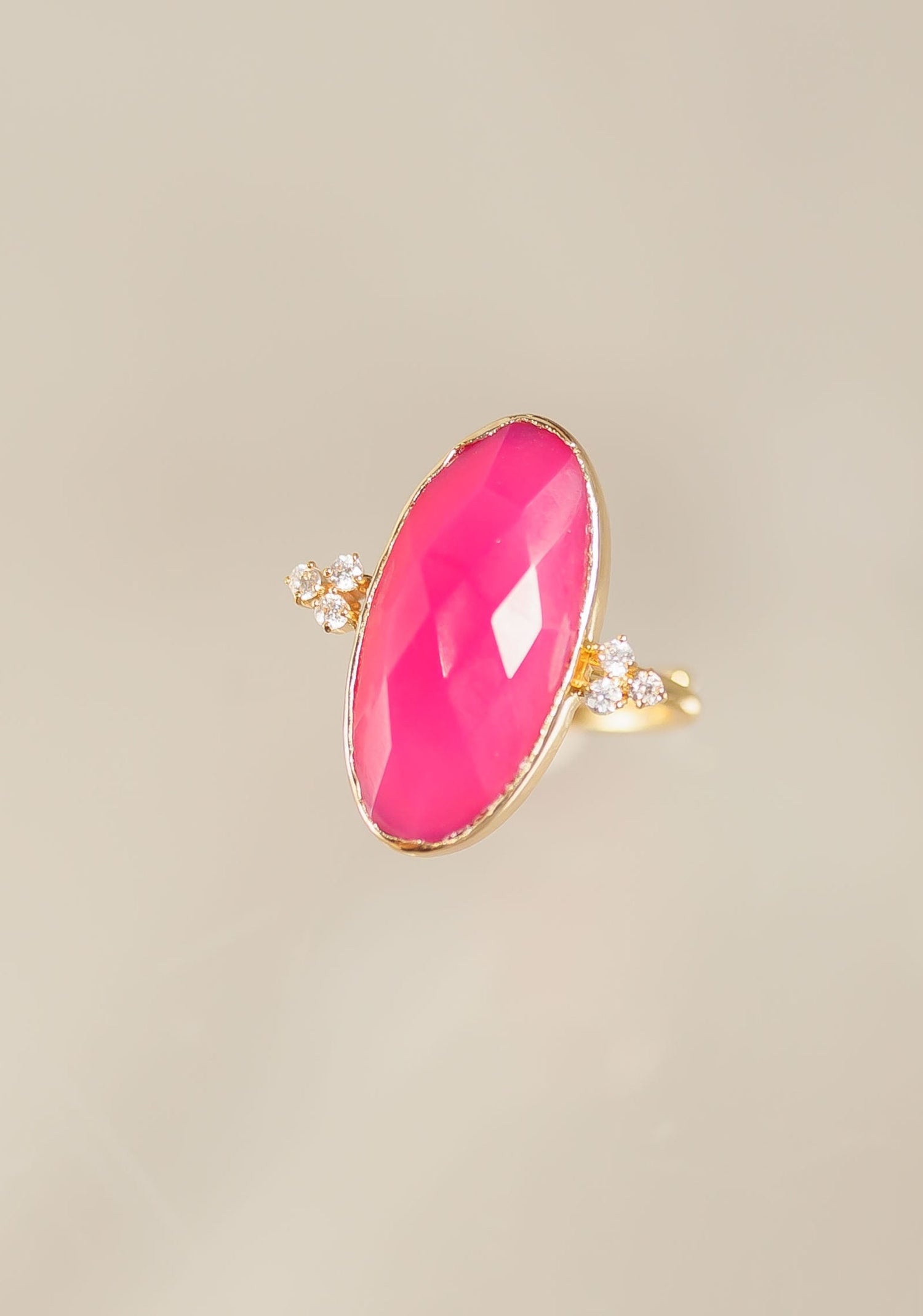 Fuchsia oval statement ring with gold band and small clear stone accents