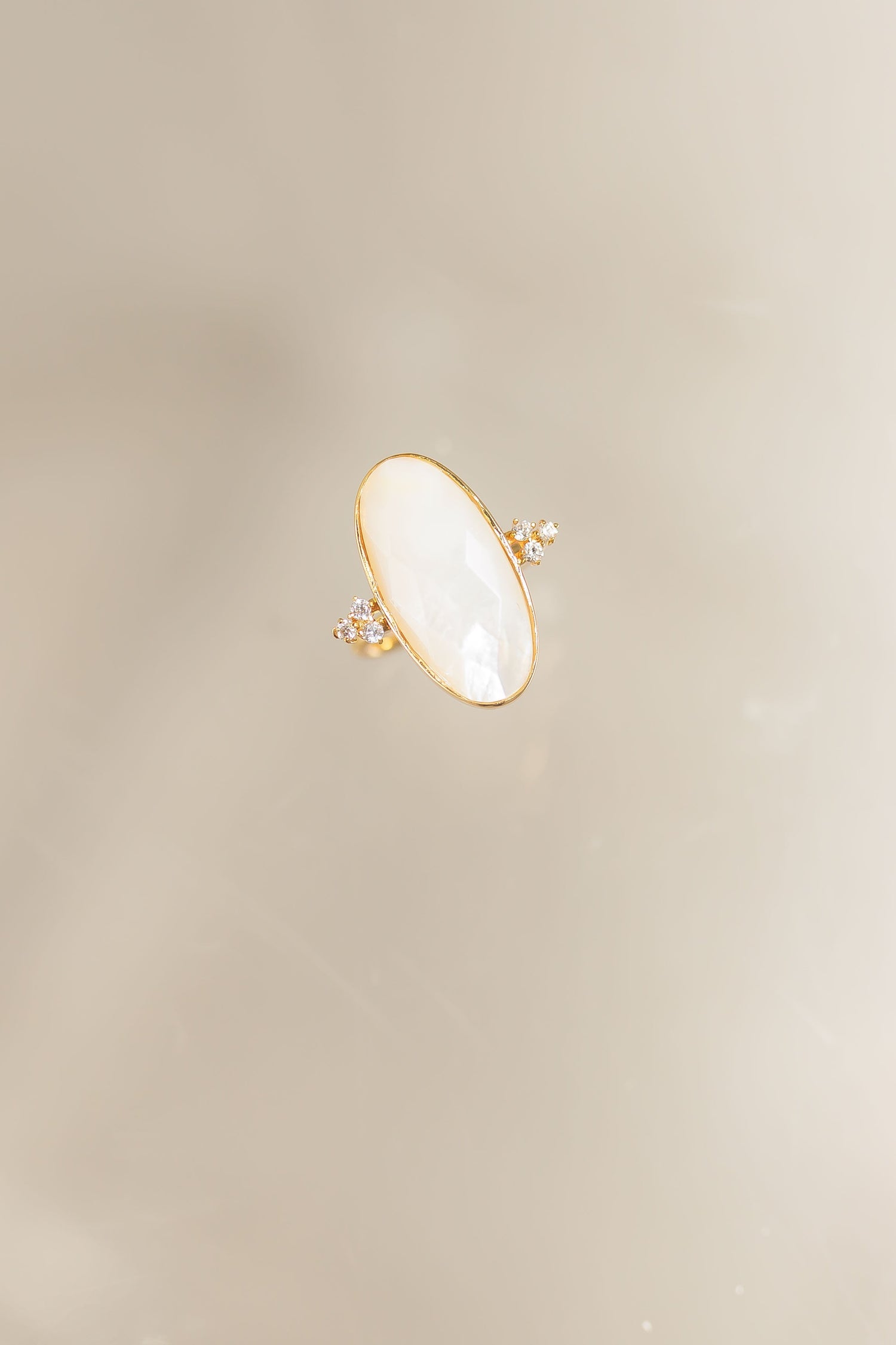 Gold-tone oval mother-of-pearl ring with small crystal accents