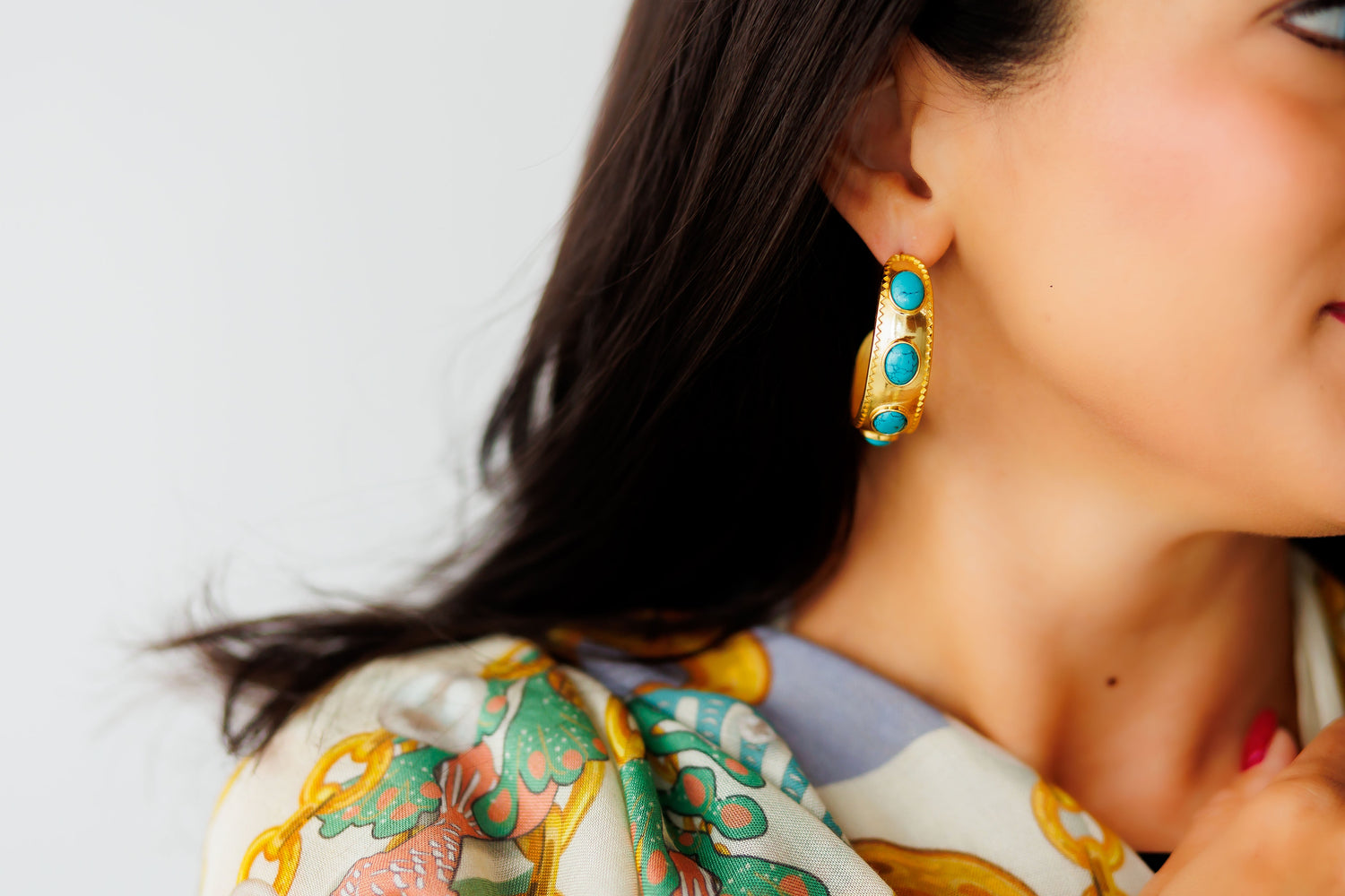 Gold-tone hoop earrings with turquoise oval stones
