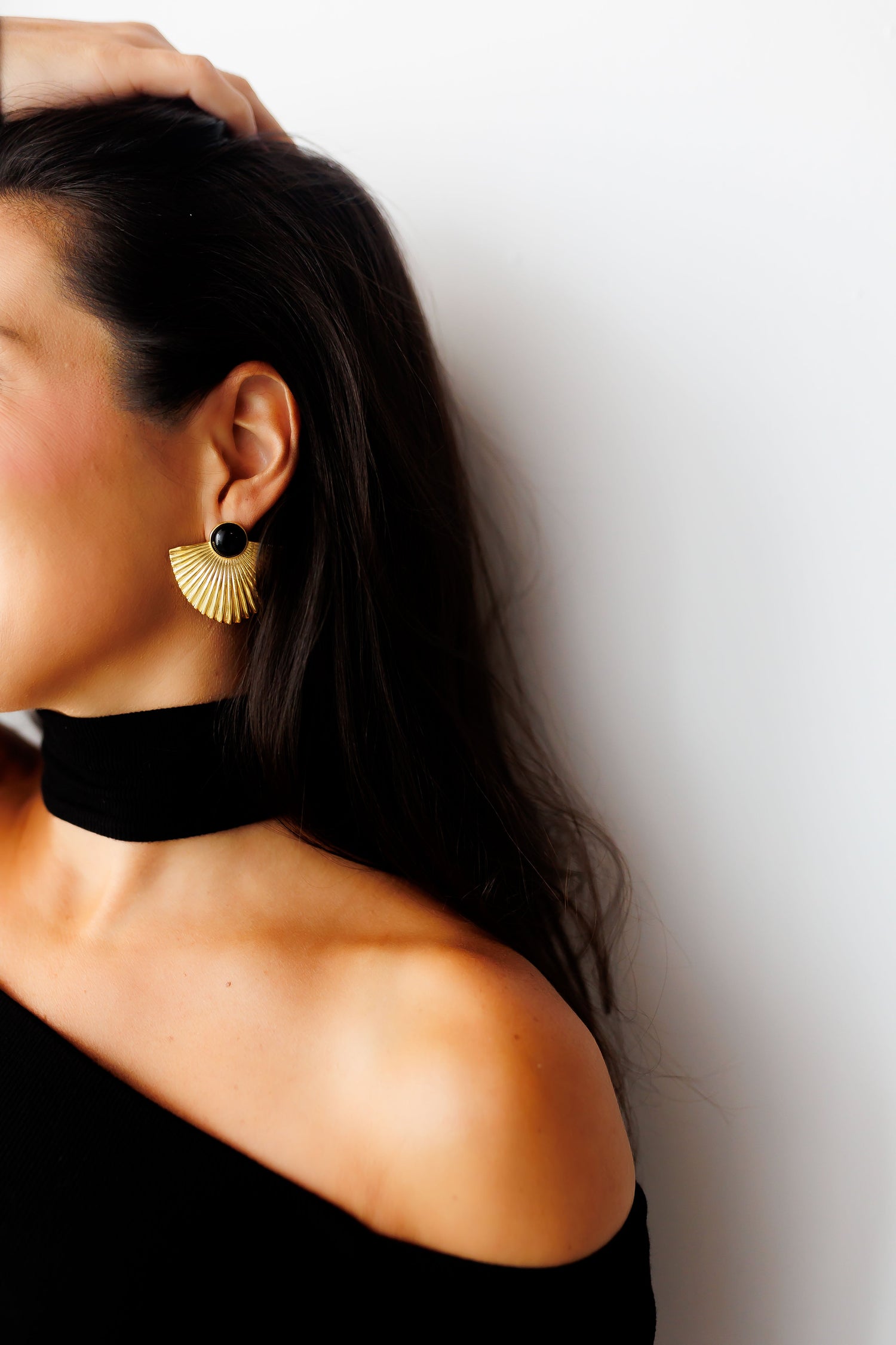 Gold fan-shaped earrings with black round stones and small pearl drops