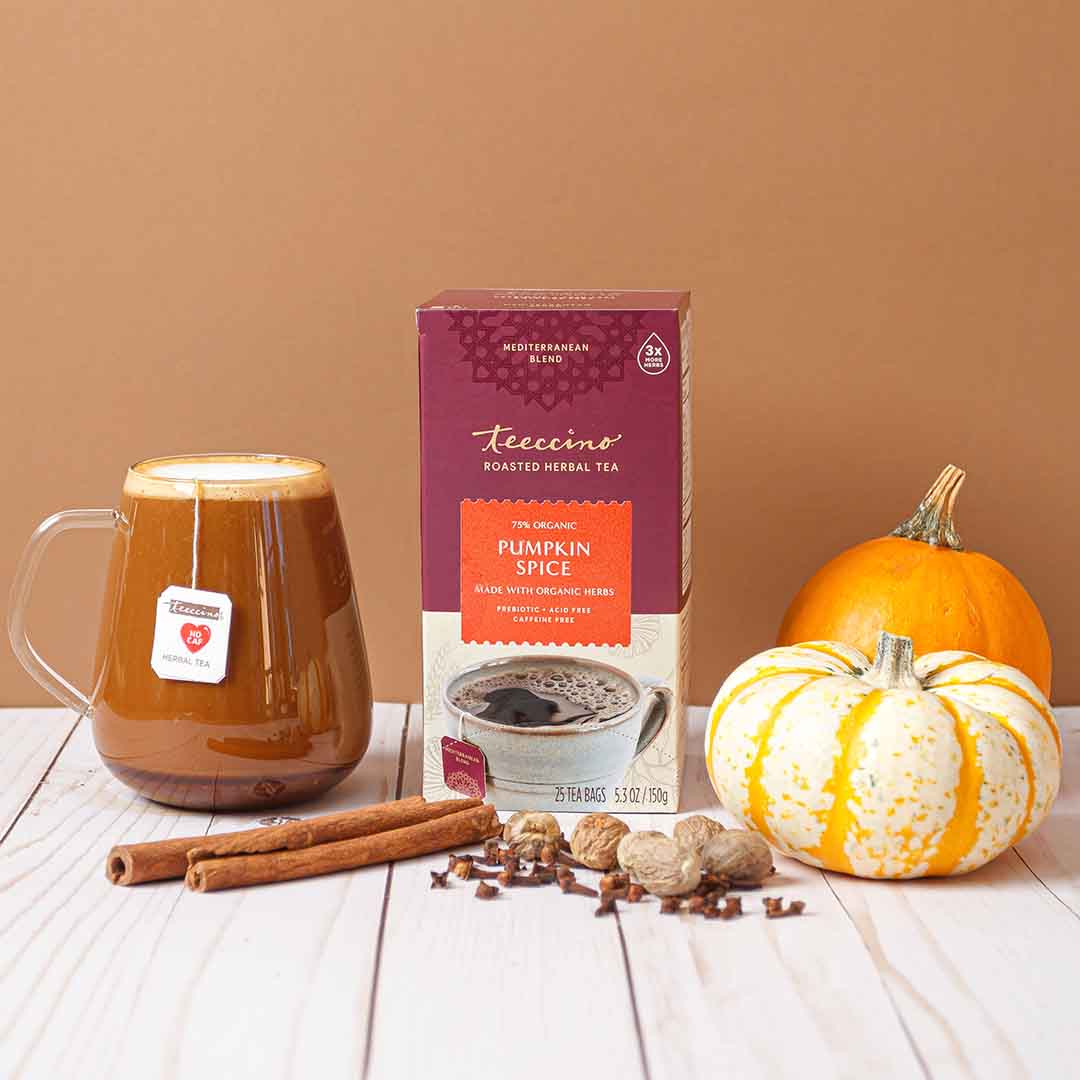 Pumpkin spice herbal tea box on table with mug and small pumpkin
