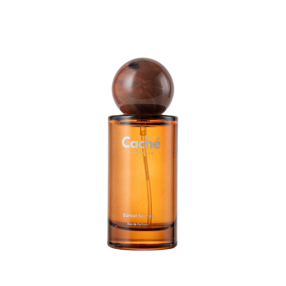 Amber perfume bottle with dark globe cap, Caché logo, front view