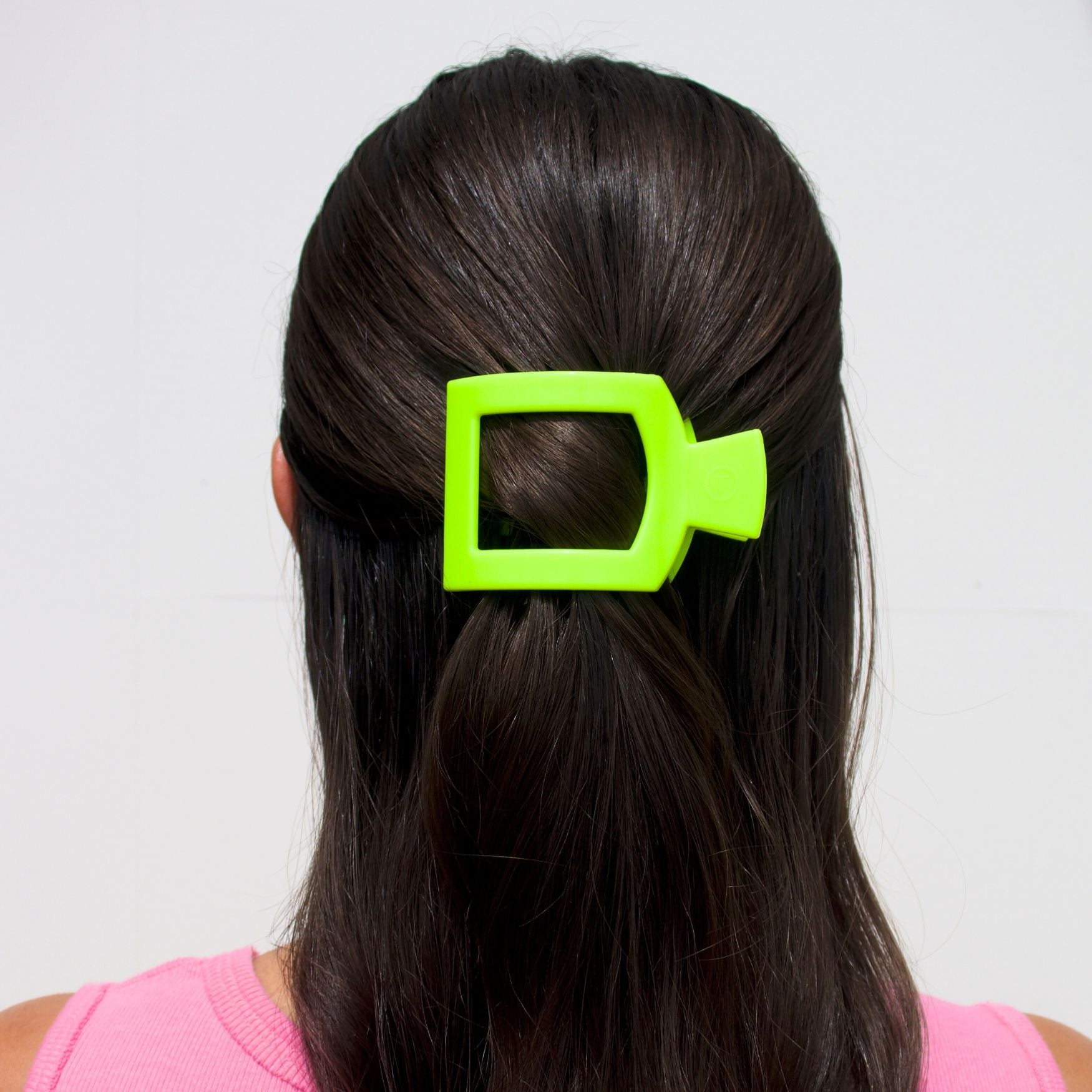 Neon lime flat square hair clip holding dark hair at the crown
