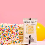 TRUBAR birthday cake flavored protein bar beside a broken cake piece with sprinkles