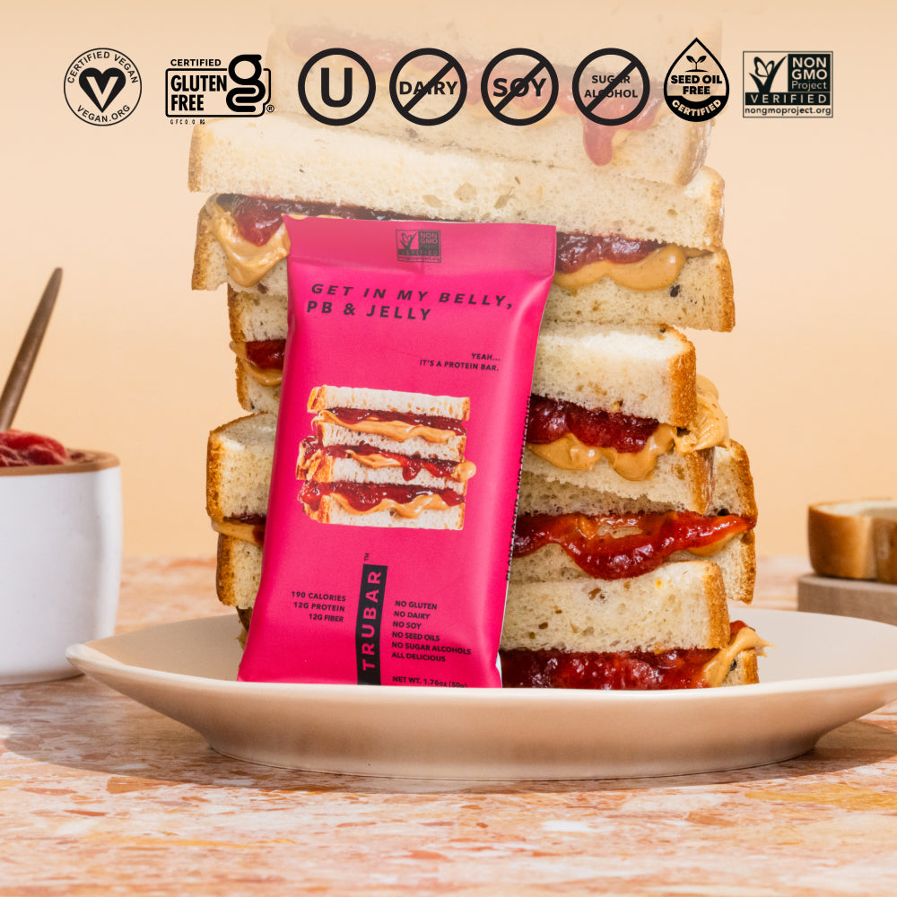 TruBar protein bar pouch standing in toast stack with icons on pink packaging