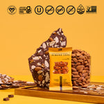 Saltylicious Almond Love yellow protein bar with chocolate pieces and almonds beside it