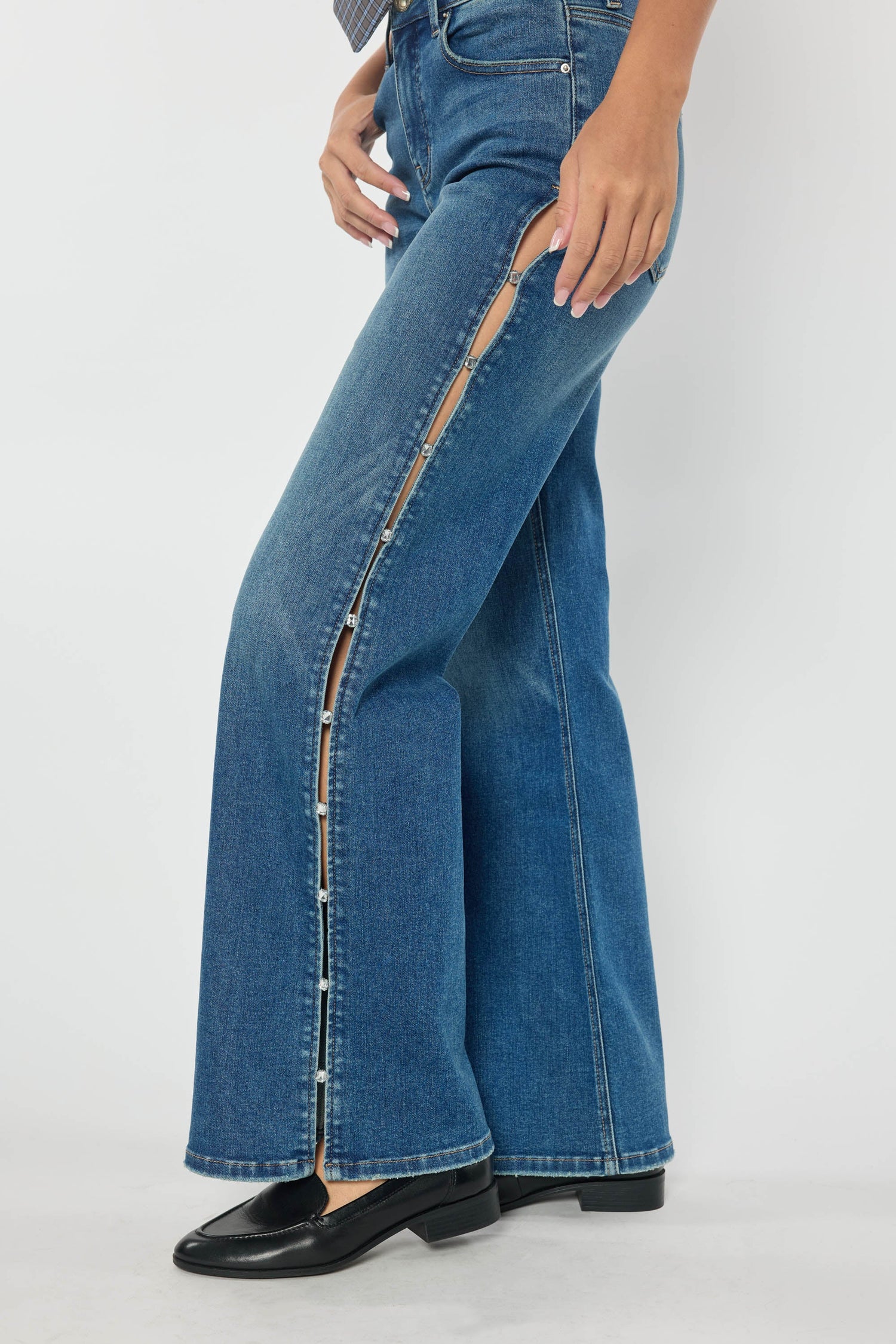 Medium wash high-rise wide-leg jeans, side view showing rhinestone-trimmed cutout