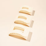 Almond beige medium flat hair clips with ridged gripping prongs close-up