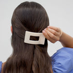 Almond beige flat rectangle hair clip on dark hair, small square cutout
