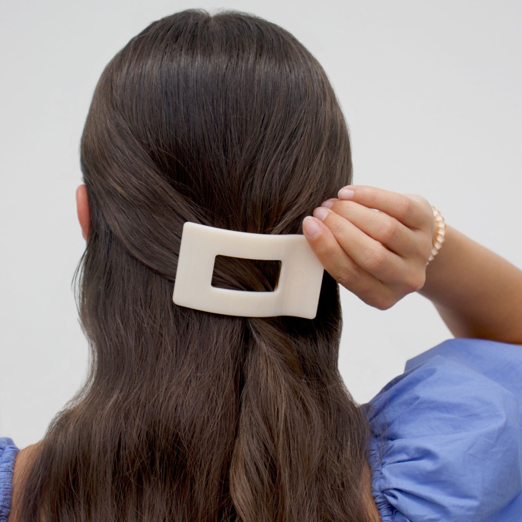 Almond beige flat rectangle hair clip on dark hair, small square cutout
