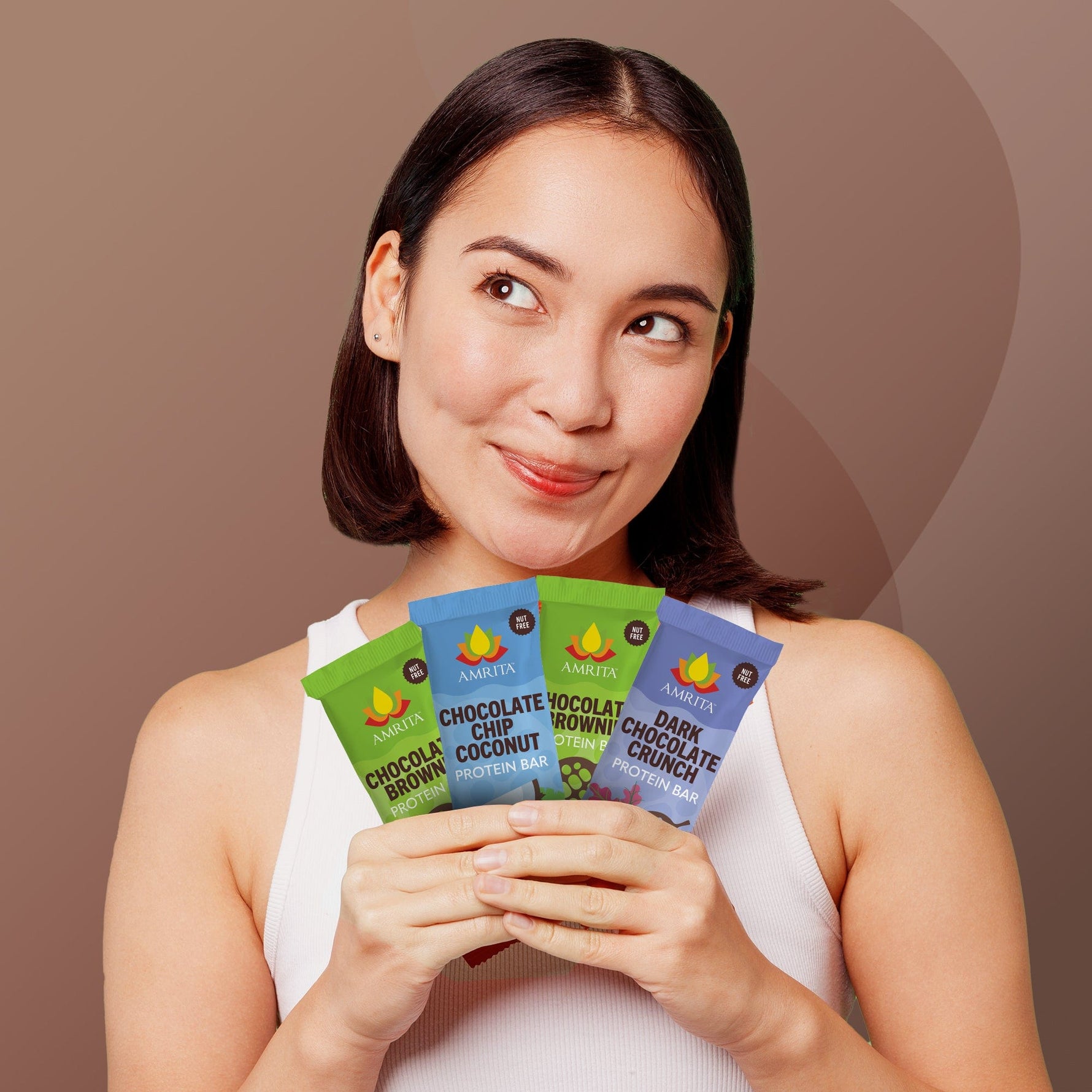 AMRITA chocolate protein bar variety pack held in hands by woman