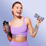 Person holding a blue-wrapped dark chocolate protein bar