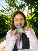 Oatmeal chocolate chip protein bar in teal wrapper held by person