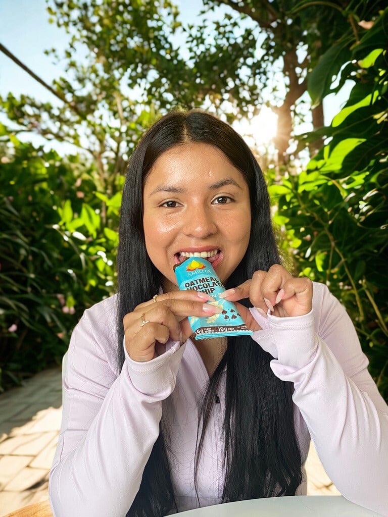Oatmeal chocolate chip protein bar in teal wrapper held by person