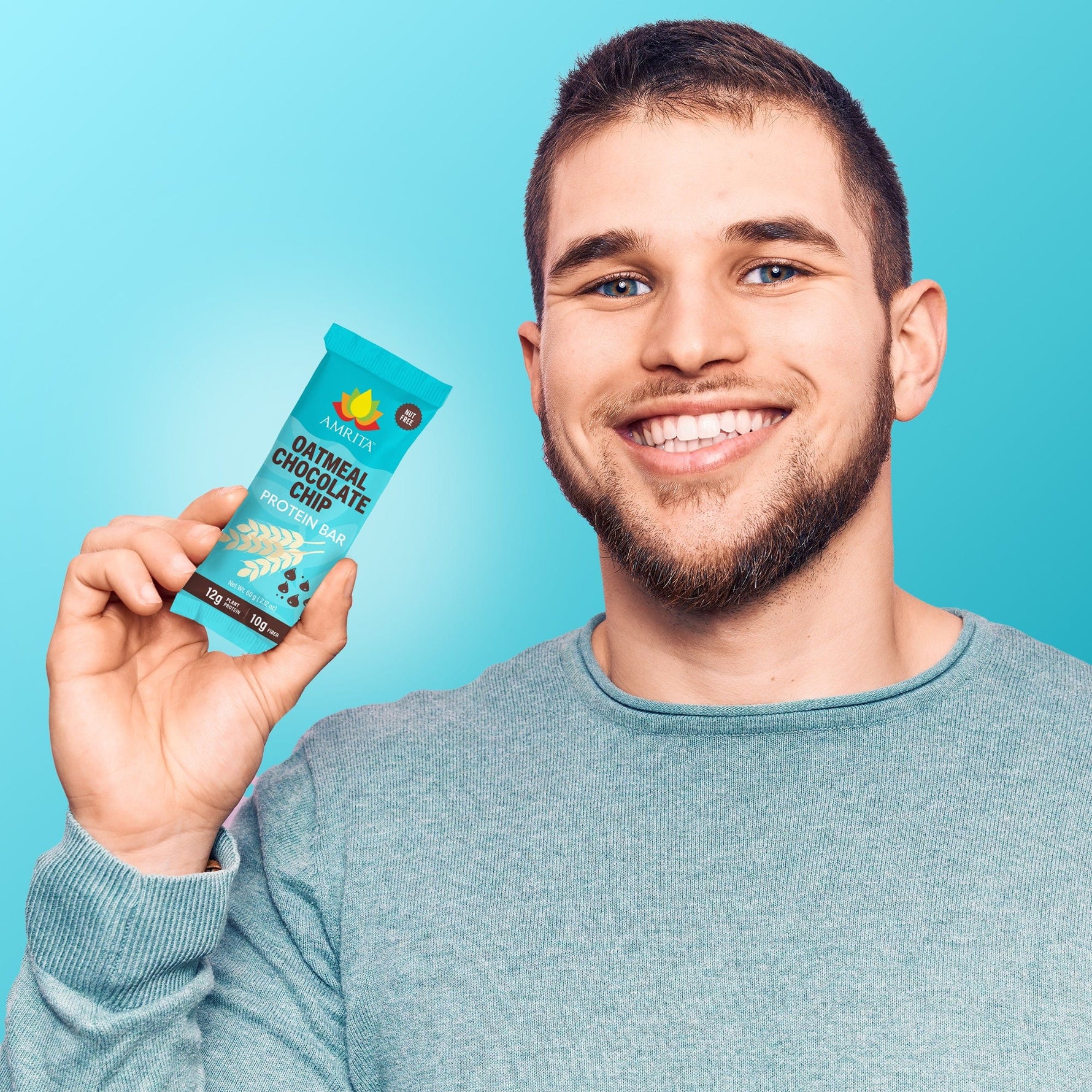 Oatmeal chocolate chip protein bar in teal wrapper held in hand