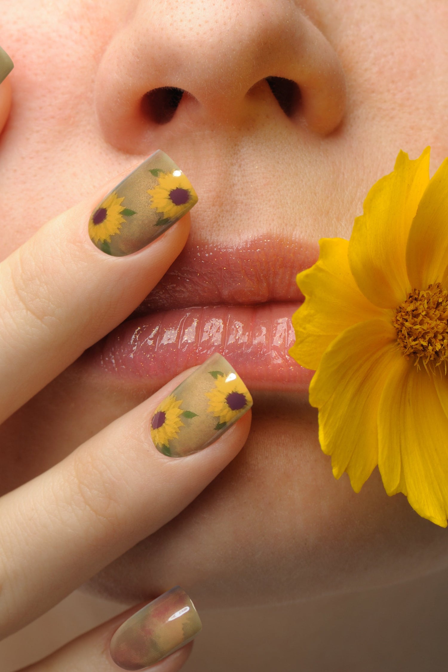 Sunflower watercolor press-on nails on fingers, tan base with yellow bloom details