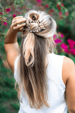 Large blonde tortoise square hair clip holding light hair in a top section
