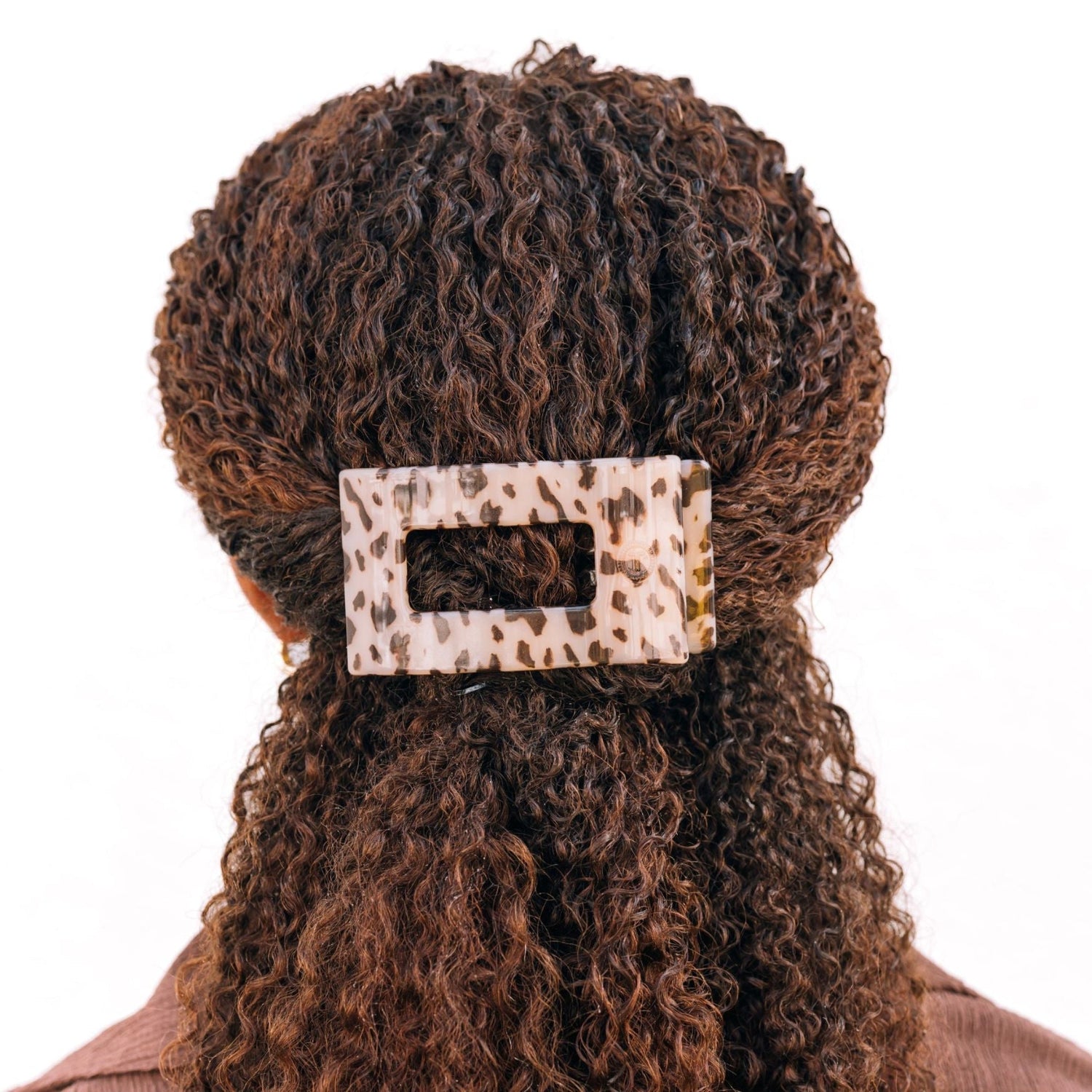 Medium flat rectangle tortoise hair clip on curly hair, beige and dark spot pattern