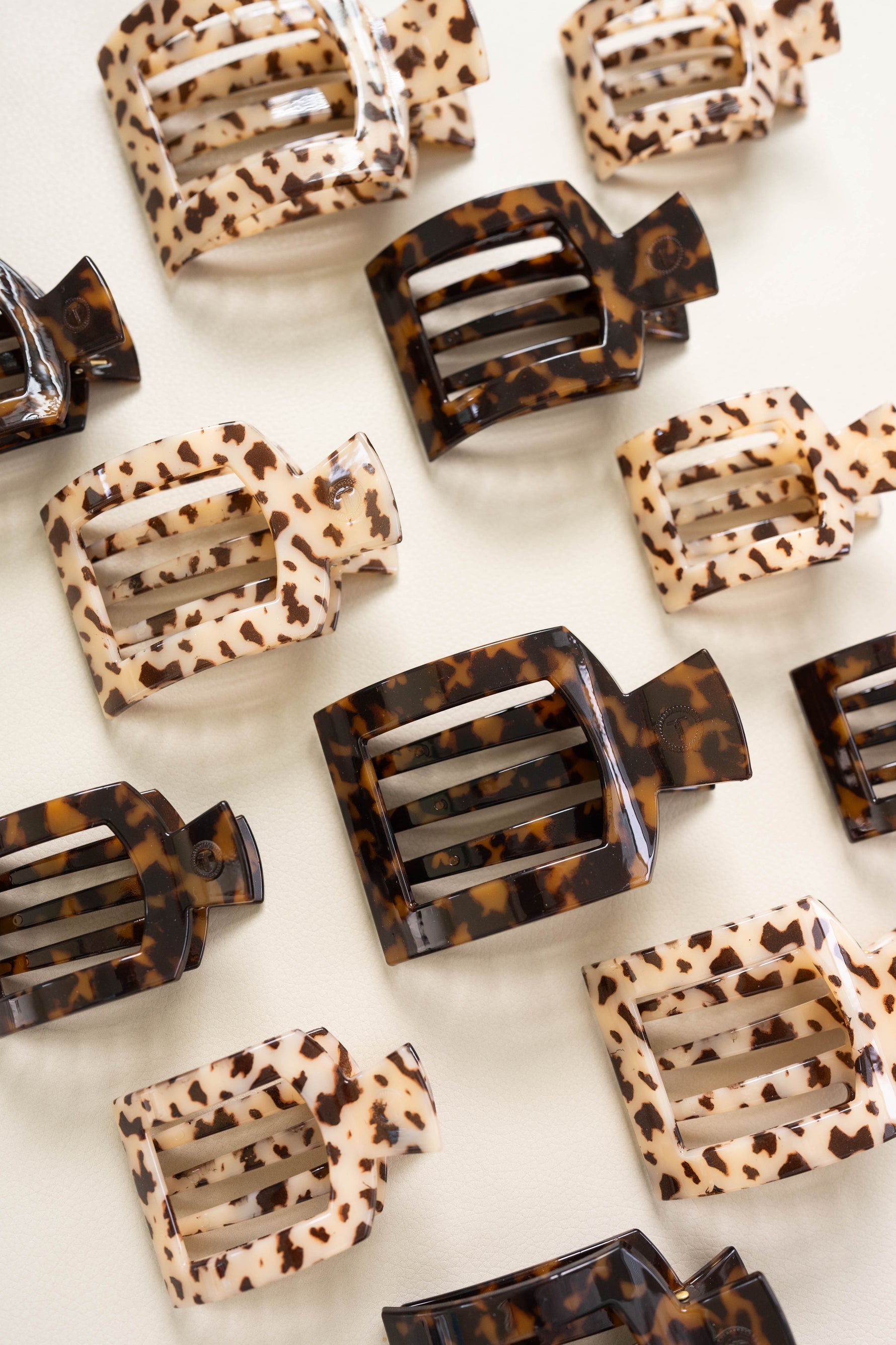 Set of flat square tortoise hair clips in beige leopard and dark brown patterns.