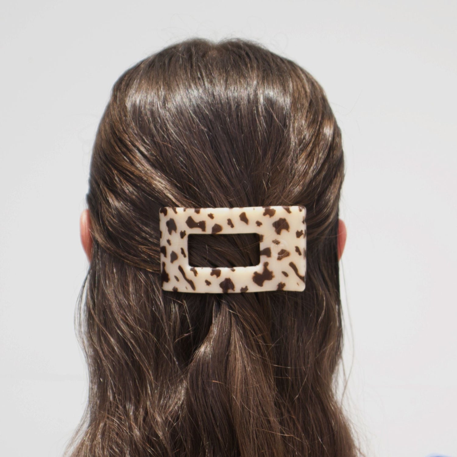 Rectangle hair clip with blonde tortoise pattern, clipped on dark hair