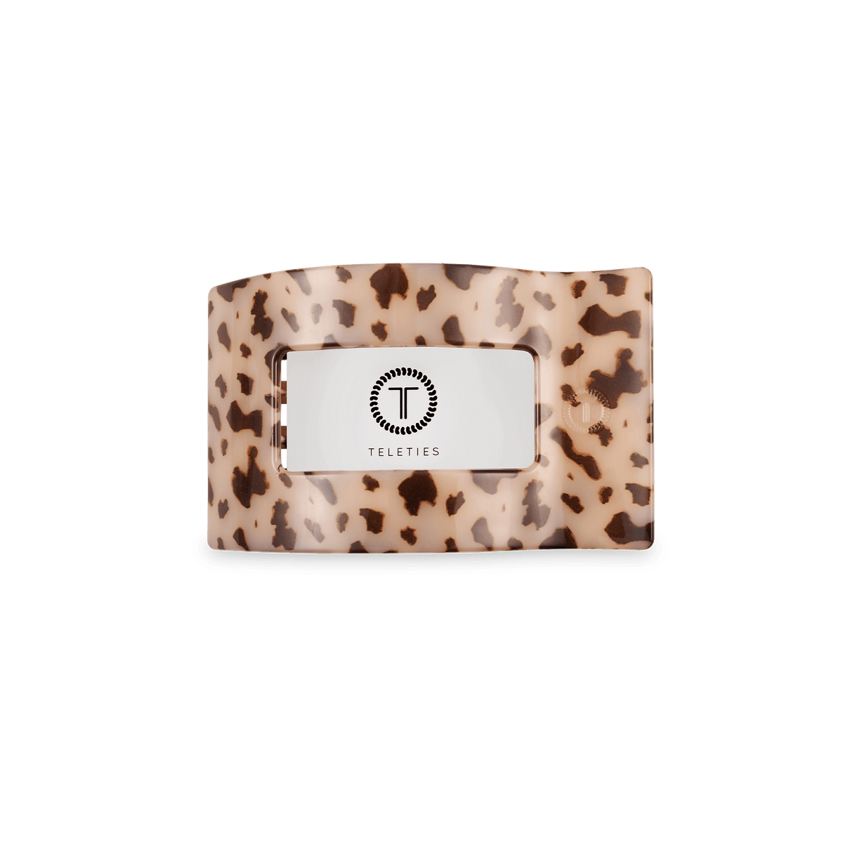 Small flat rectangle hair clip with blonde tortoise pattern and centered logo plate