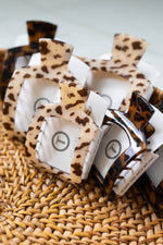 Tortoise-effect square hair clips with leopard print on a woven surface
