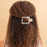 Tortoise-effect square hair clip with leopard print pattern on curly hair