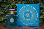 Eau de parfum bottle and blue box with circular gold NYC logo