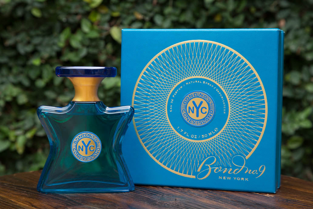 Eau de parfum bottle and blue box with circular gold NYC logo