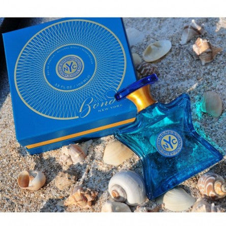 Eau de parfum bottle beside blue box, teal glass with NYC emblem