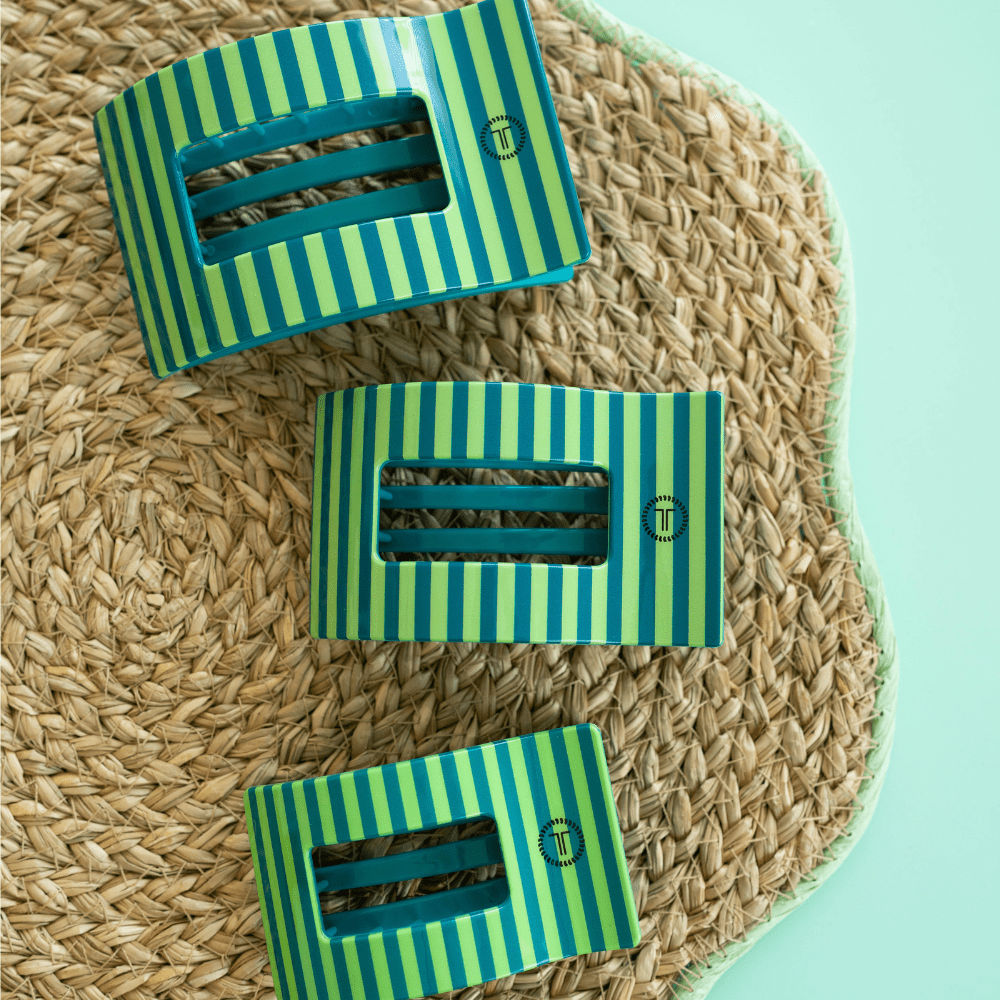 Three rectangular hair clips with teal and green vertical stripes on a straw hat.