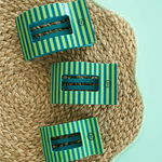 Three rectangular hair clips with teal and green vertical stripes on a straw hat.