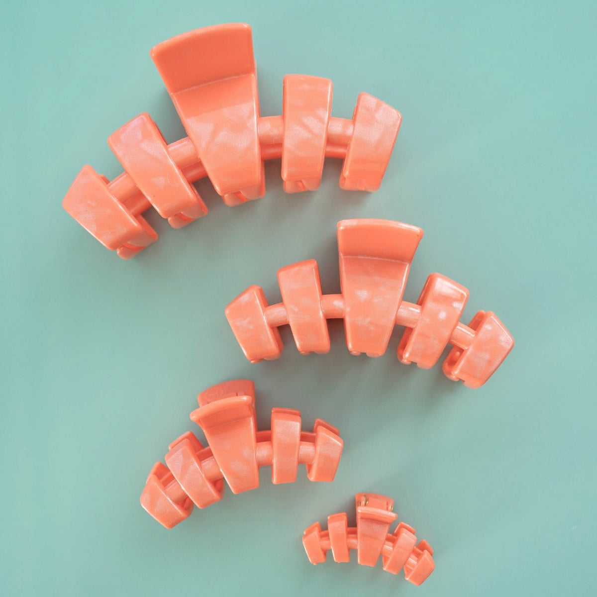Set of coral-orange tiny claw clips with five-prong design