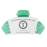 Mint green large claw hair clip with attached cardboard branding card
