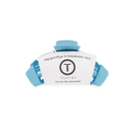 Sky-blue claw hair clip holding a small product label card
