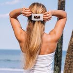 Large flat rectangle hair clip holding long blonde hair at the back