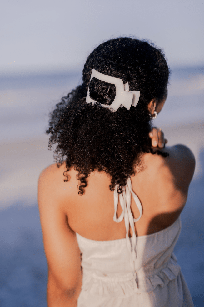 Large white square hair clip on curly hair, side-mounted