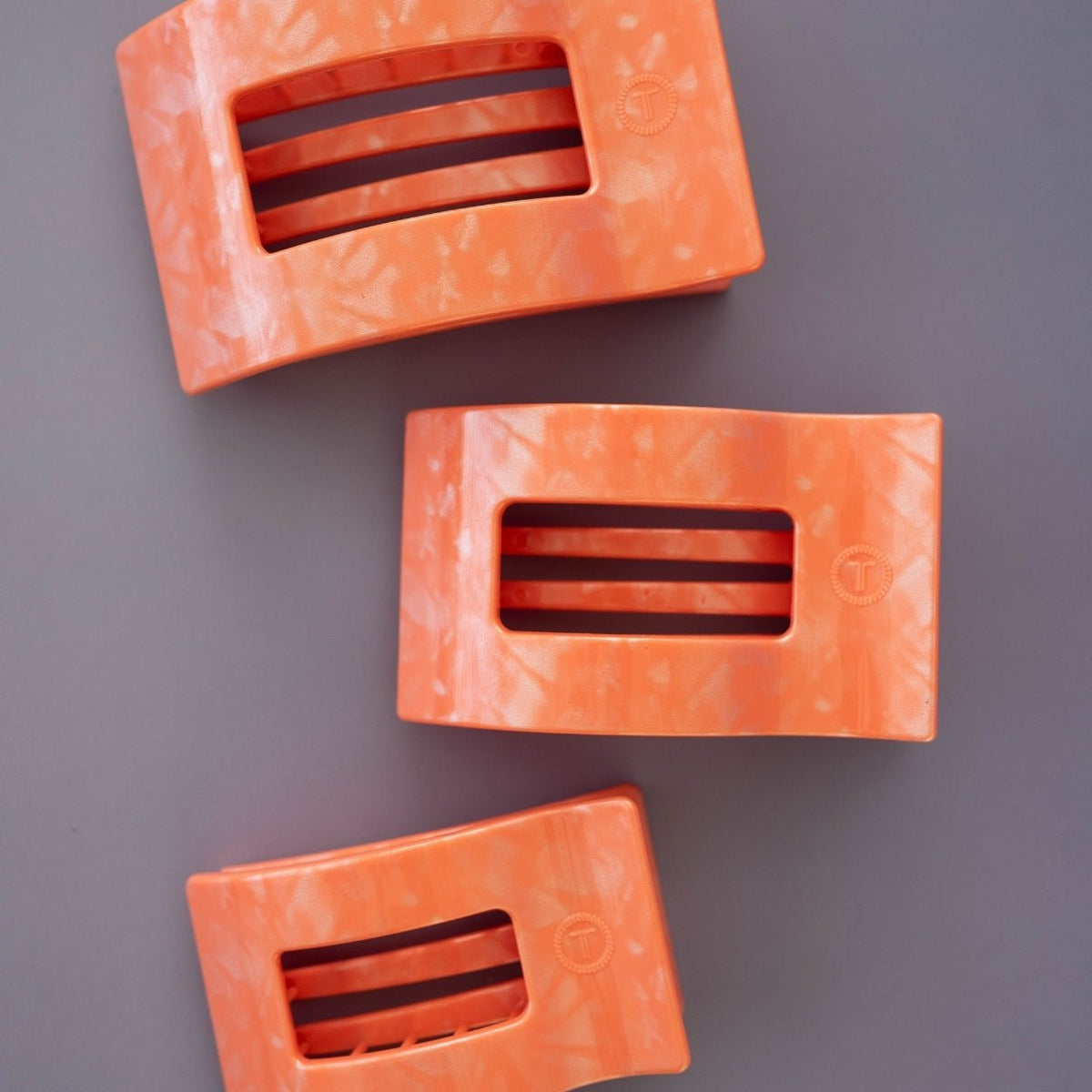 Set of coral-pink flat rectangle hair clips with cutout slots