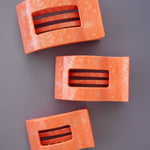 Set of coral-pink flat rectangle hair clips with cutout slots