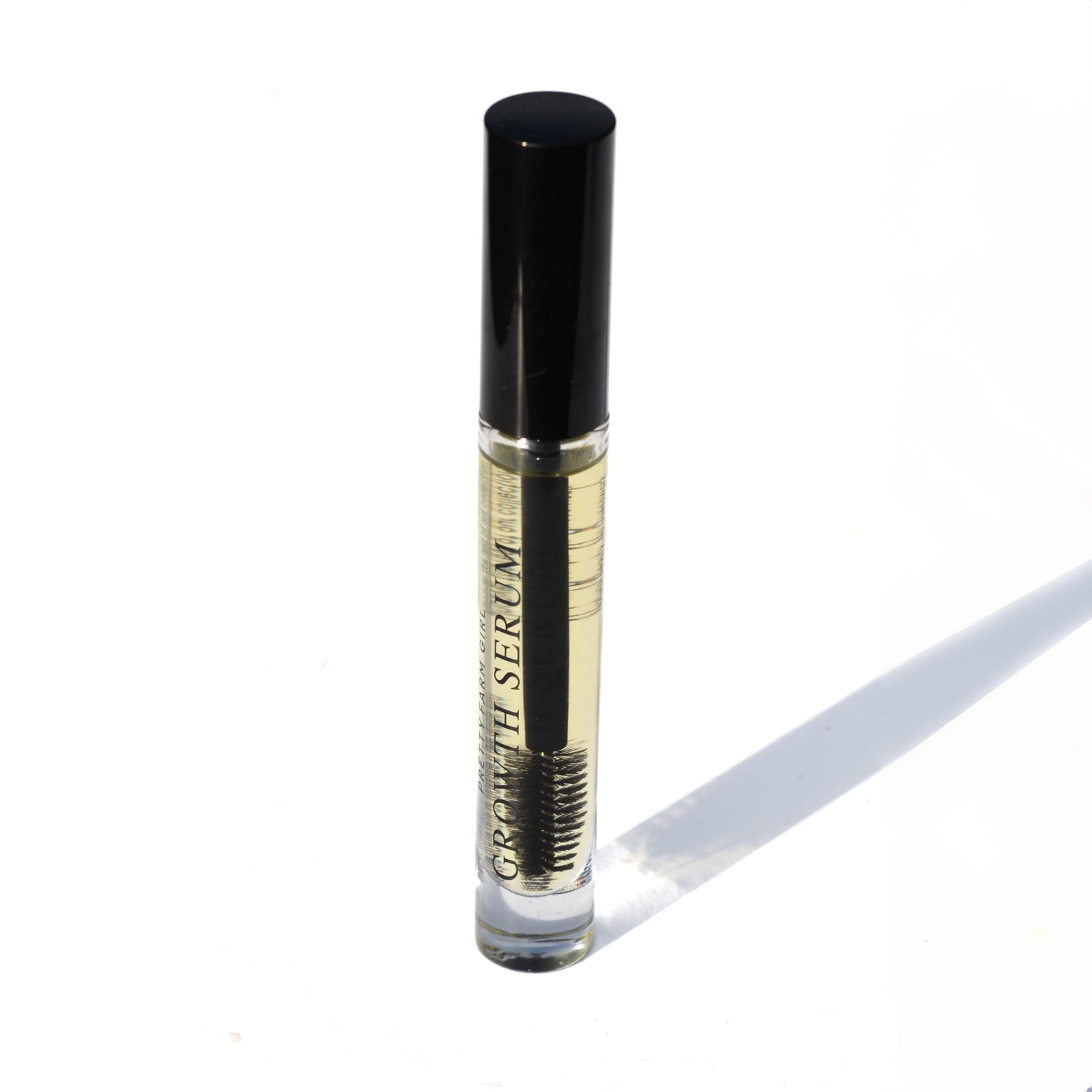 Growth serum bottle with black cap and wand-style brush for lashes and brows