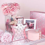 Rose-pink Eau de Parfum bottle with logo-patterned glass and shiny metal cap
