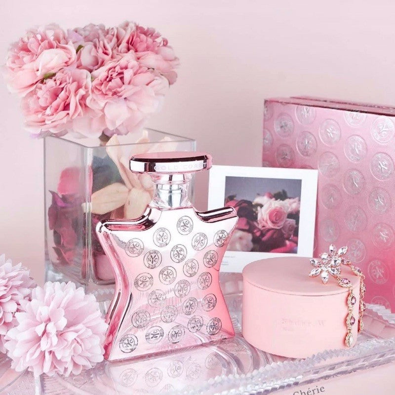 Rose-pink Eau de Parfum bottle with logo-patterned glass and shiny metal cap