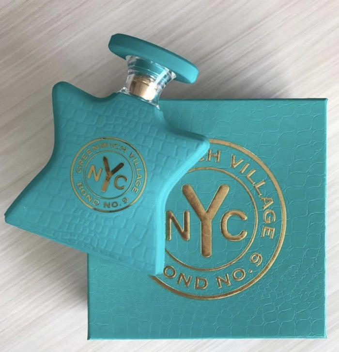 Teal eau de parfum bottle with gold NYC Greenwich Village emblem and blue-green cap