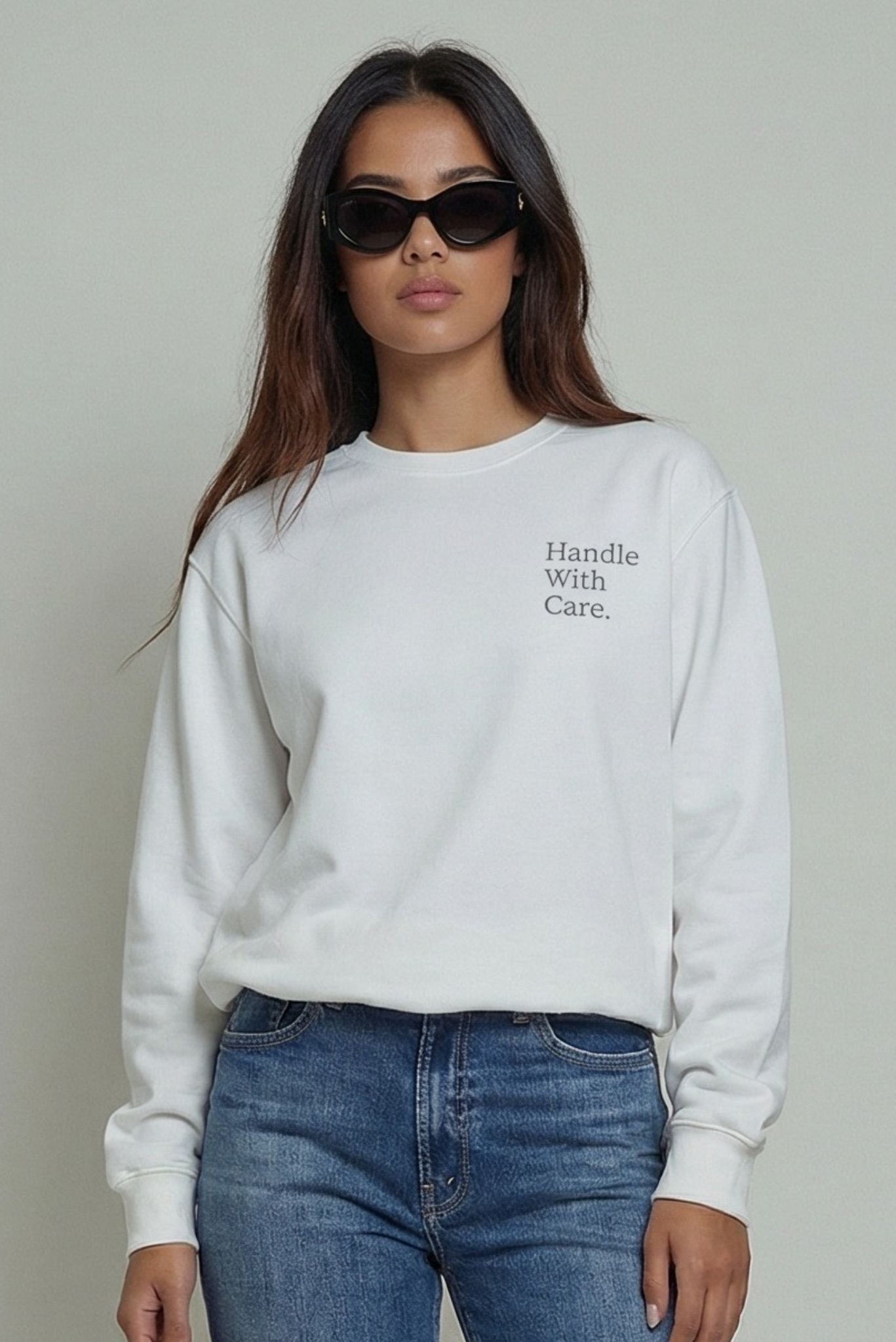 White sweatshirt with "Handle With Care" printed on the front, crewneck