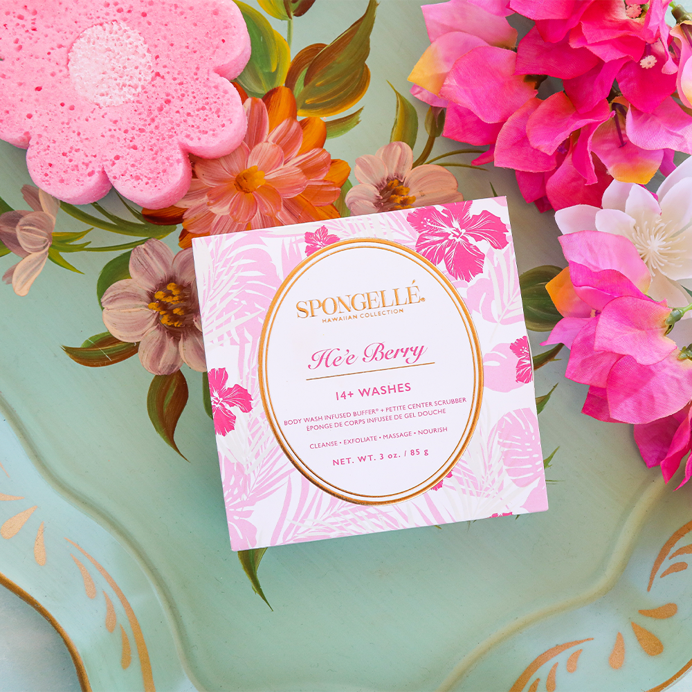 Pink flower-shaped body scrub buffer next to Spongelle He'e Berry gift box